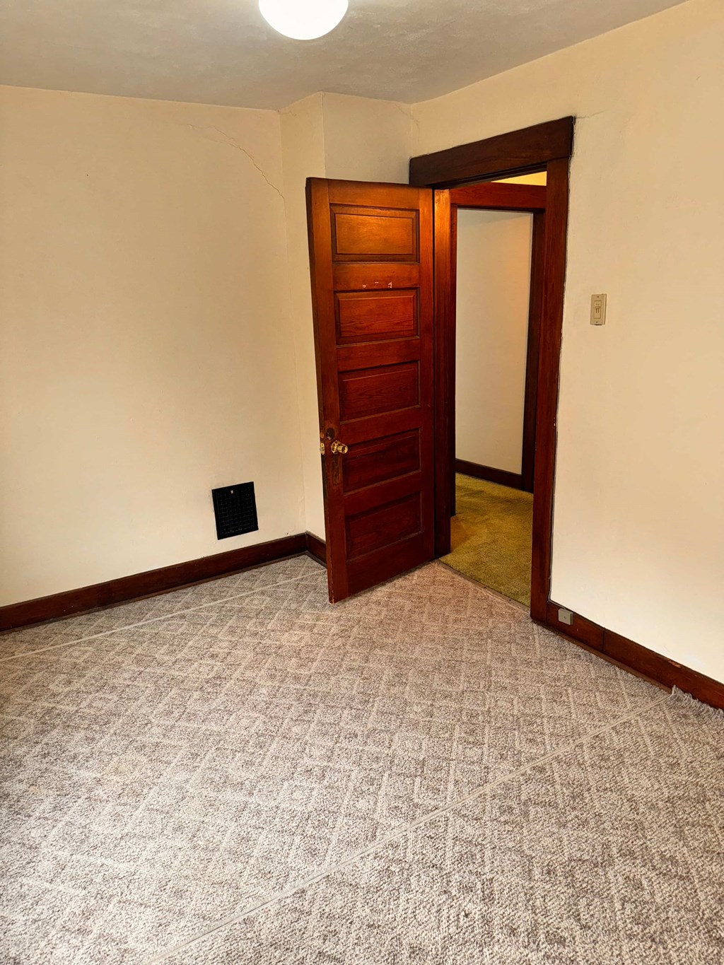 a room with a door and a carpeted floor