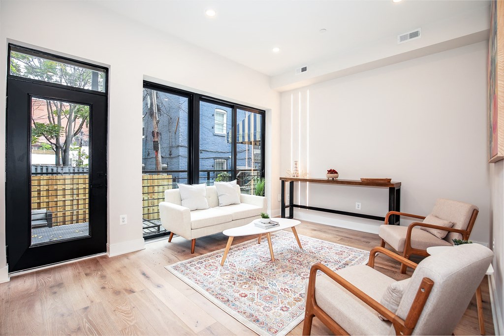 a living room with a couch and chairs and sliding glass doors