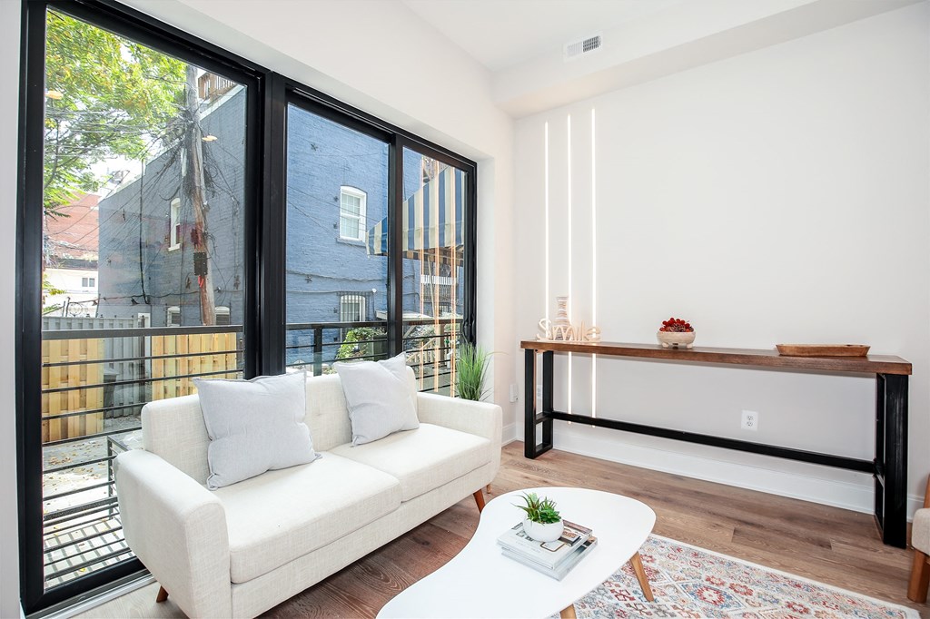 a living room with a white couch and a balcony