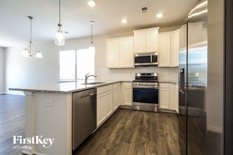 a kitchen with white cabinets and stainless steel appliances