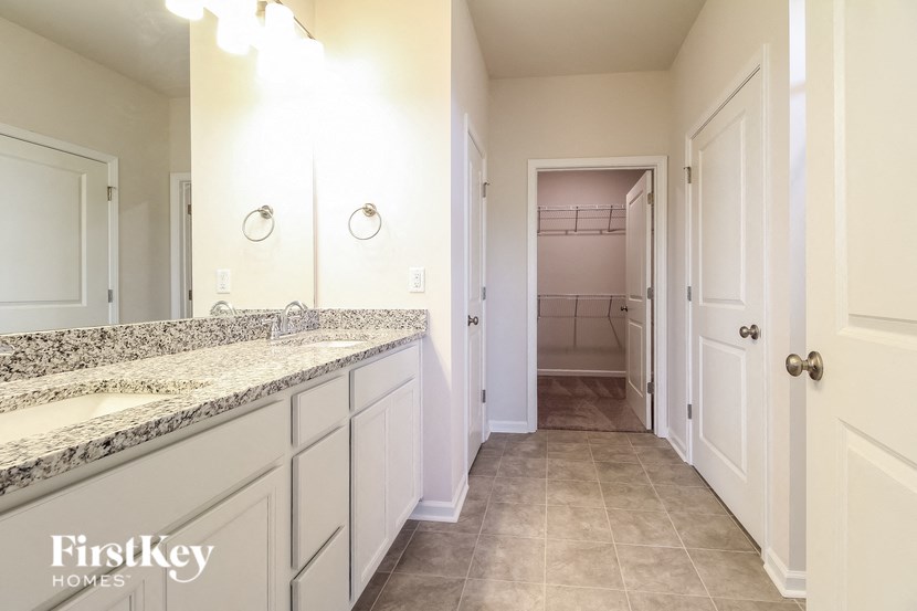 a large bathroom with white cabinets and a long counter top