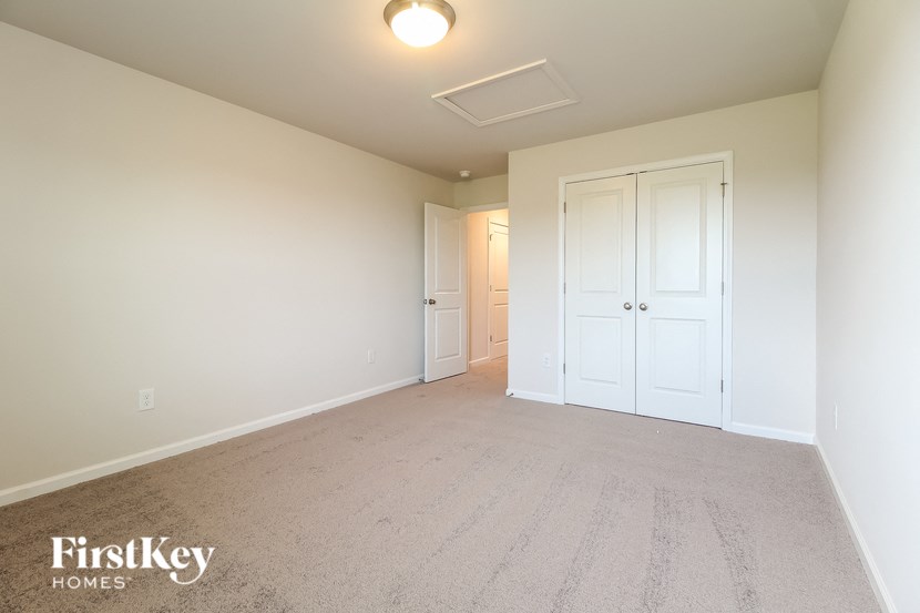 a master bedroom with a carpeted floor and white doors
