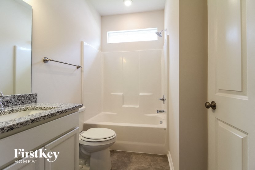 a white bathroom with a toilet and a shower