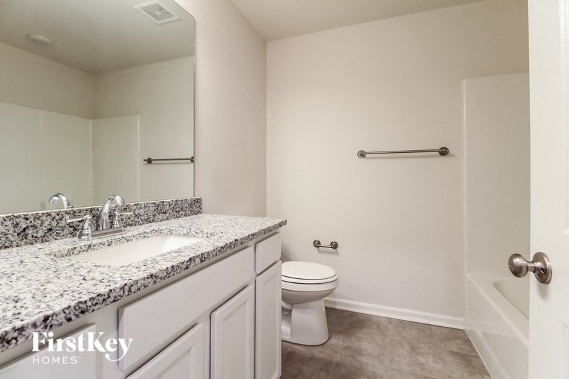 a bathroom with a toilet and a sink and a mirror