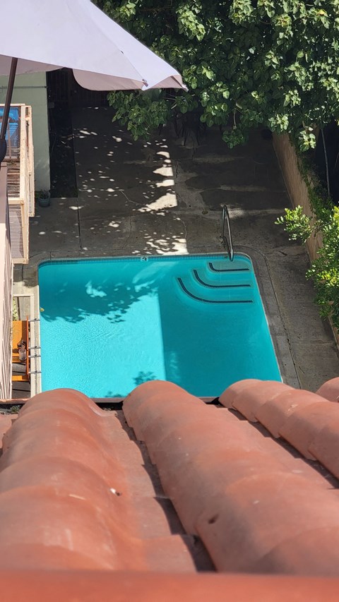 a hot tub in the backyard of a house with an umbrella