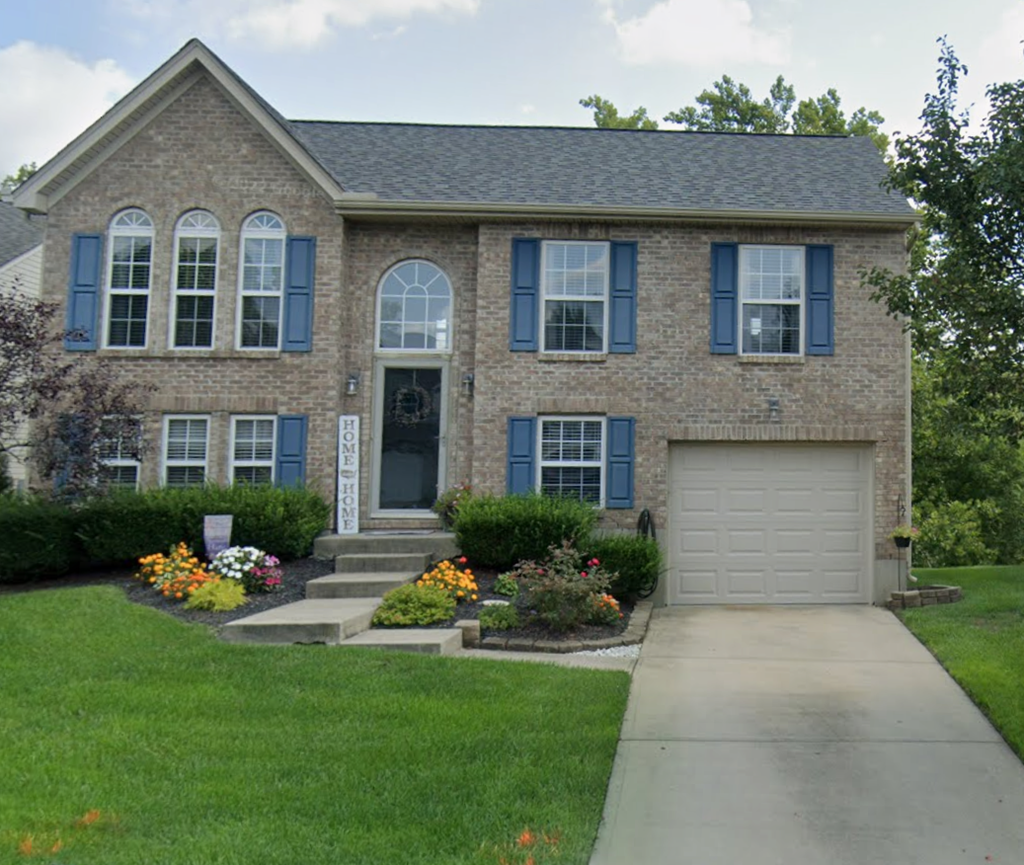 a brick house with blue shutters and a white garage door