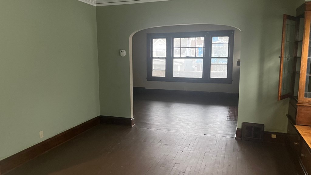an empty living room with green walls and a window