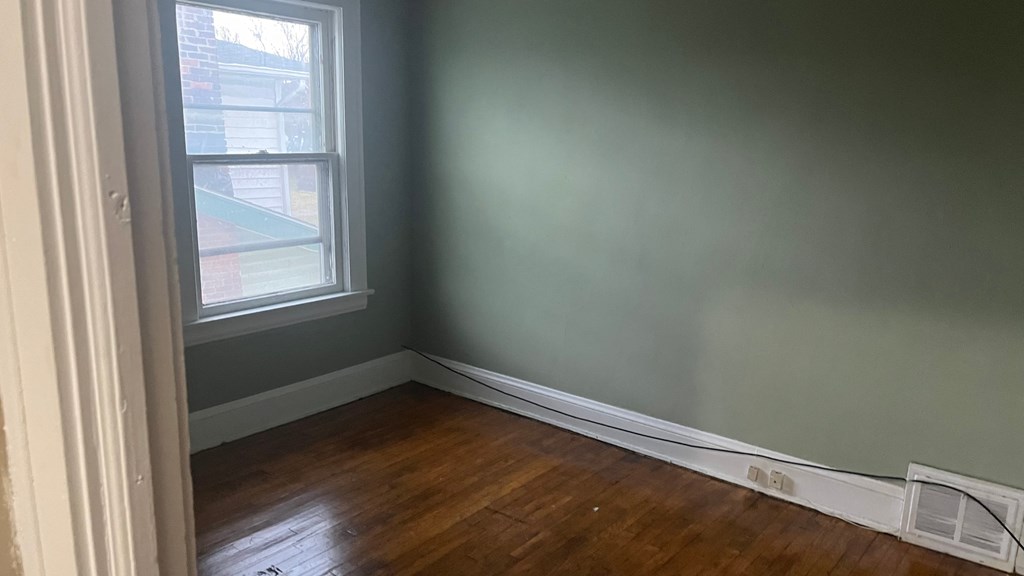 the corner of a room with green walls and a window