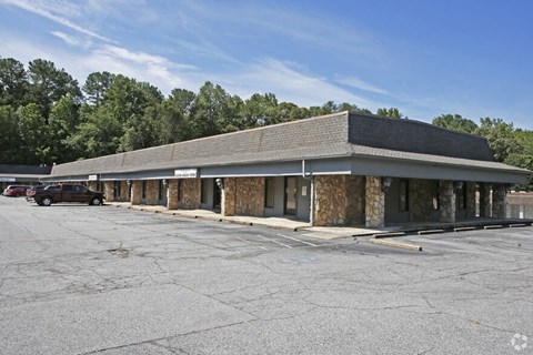 the front of a building with a parking lot