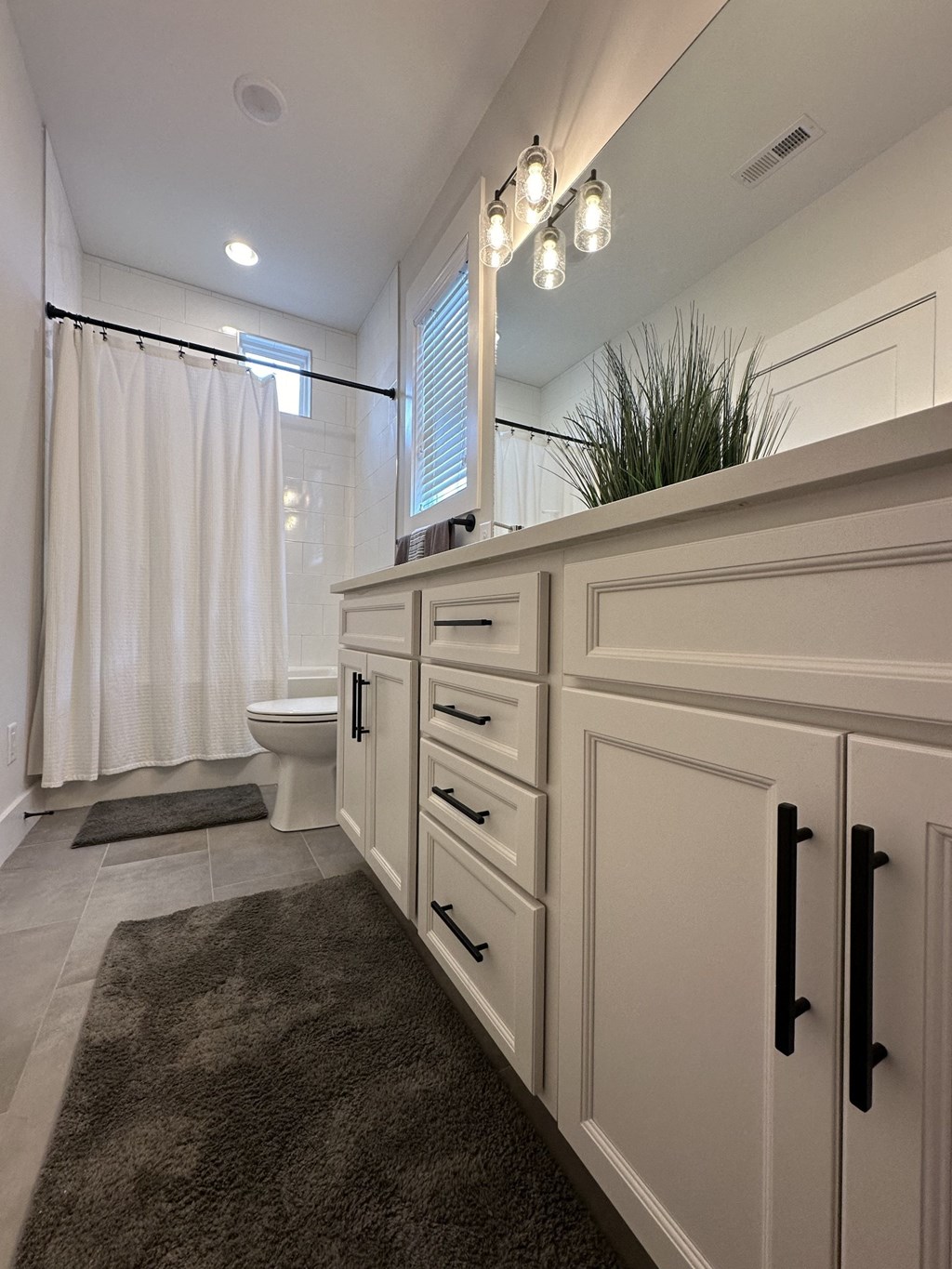 a bathroom with white cabinets and a shower and a toilet