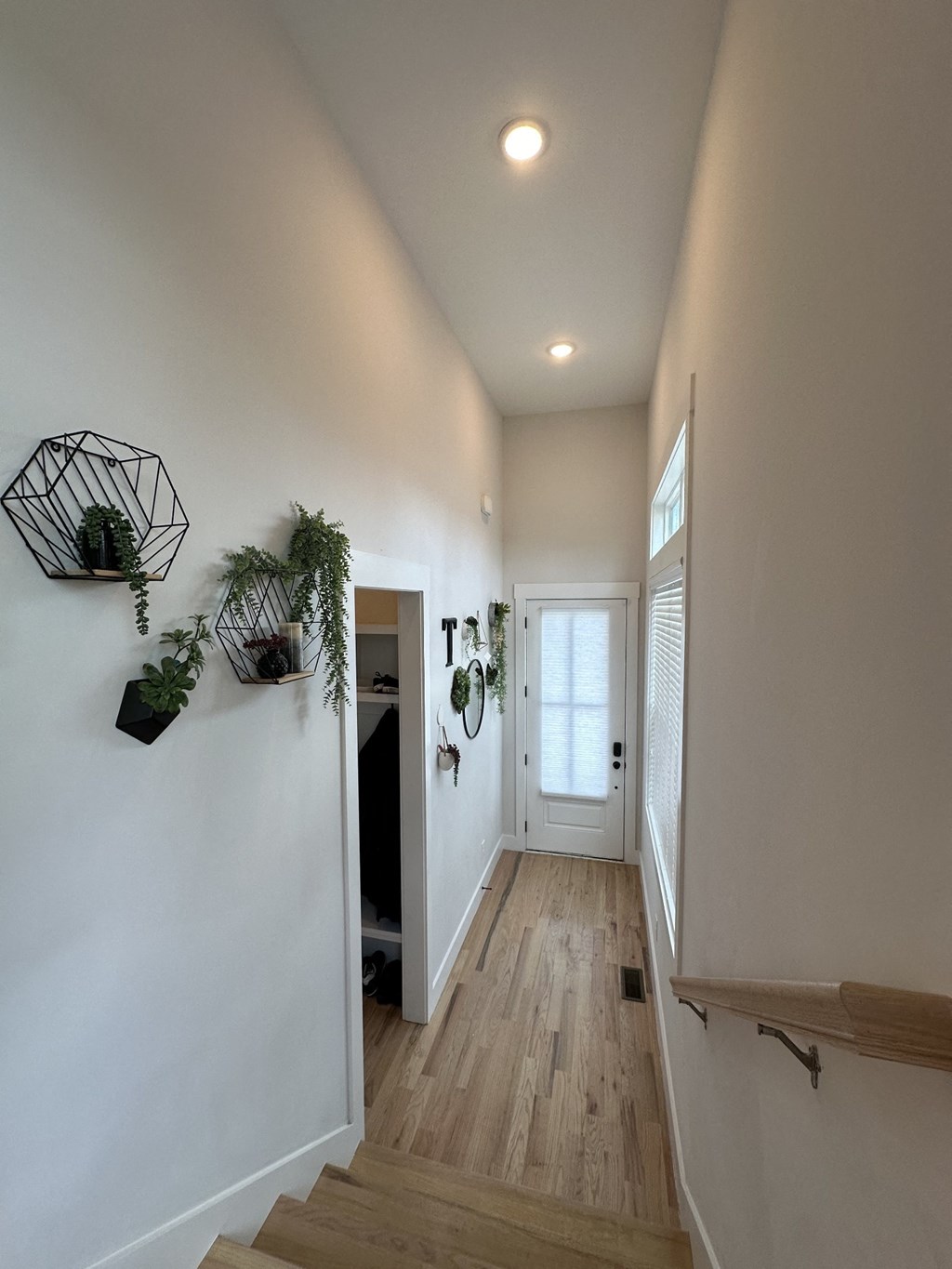a long hallway with white walls and wood floors