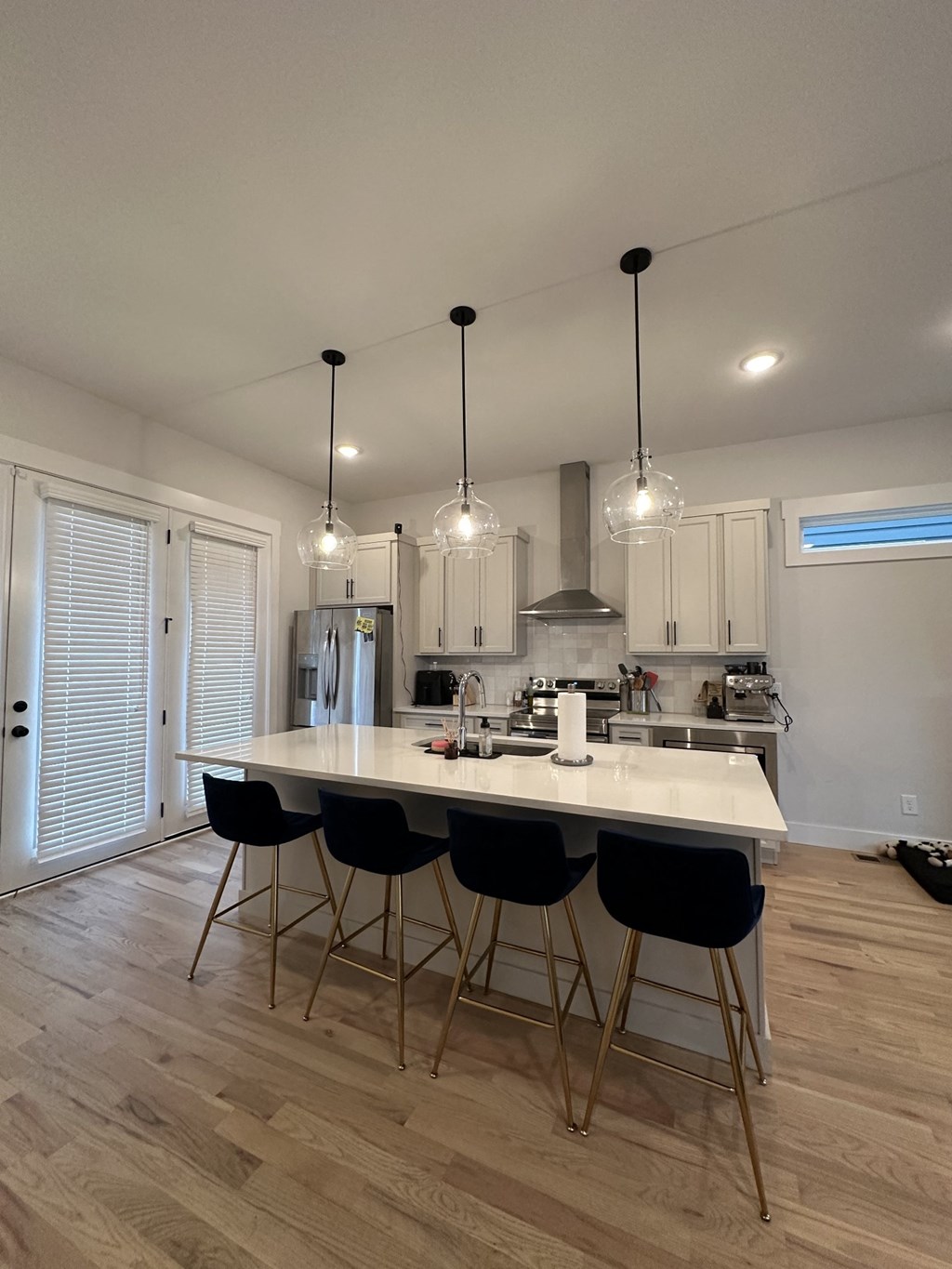 a kitchen with a marble counter top and black bar stools