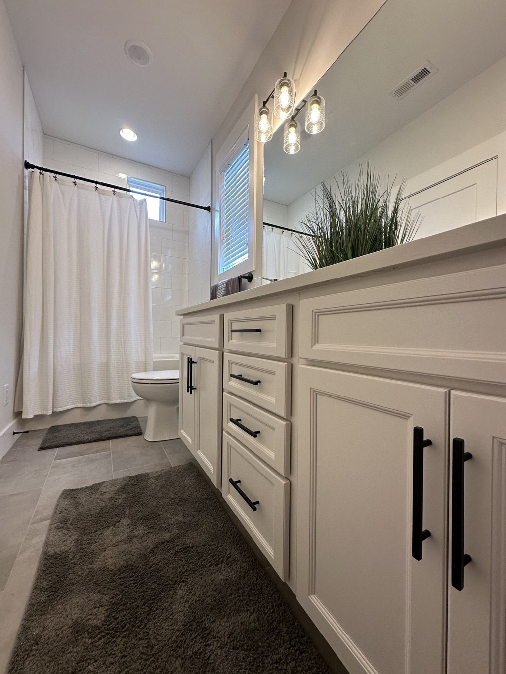 a bathroom with white cabinets and a shower and a toilet