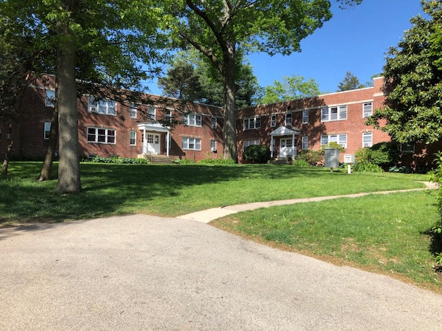 A red brick building with a tree in front of it.