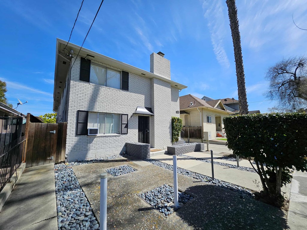 a white brick house with a yard in front of it