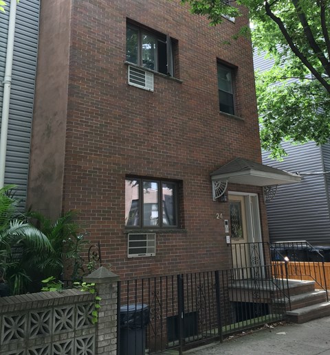 A brick building with a black gate in front.