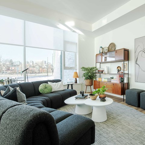 a living room with a large window and couches and a coffee table