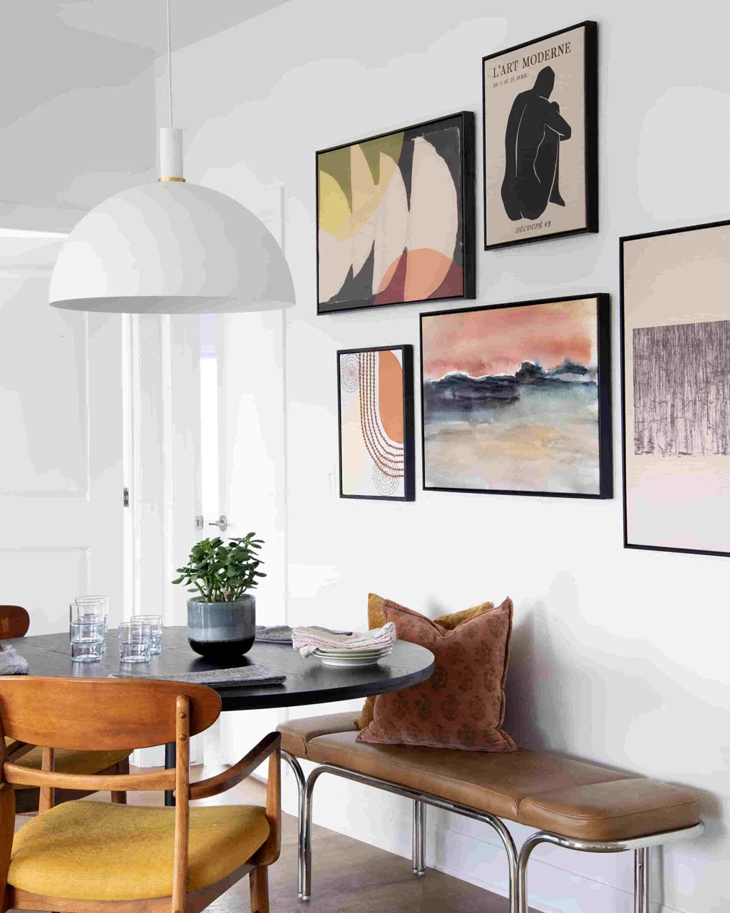 a dining room with a table and chairs and pictures on the wall