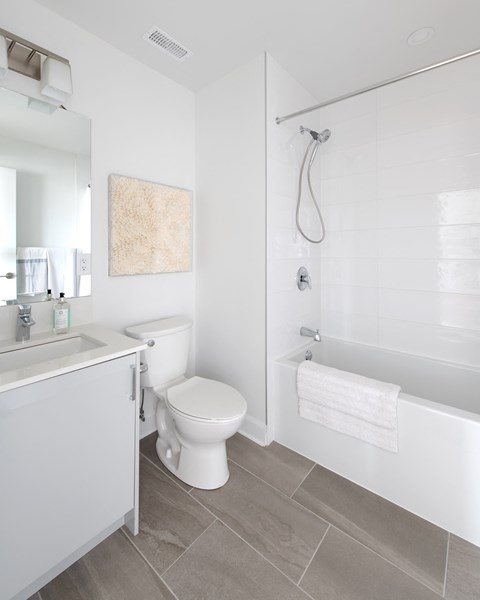 a white bathroom with a toilet and a shower