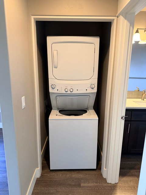 A white washing machine is in a small laundry room.