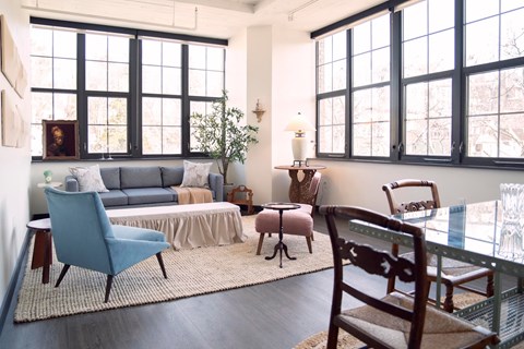 A living room with a blue chair and a grey couch.