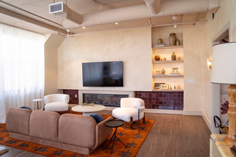 A living room with a couch, a chair, a table, and a television.