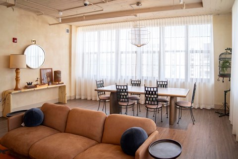 A living room with a brown sofa and a round table.