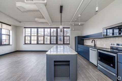 A modern kitchen with a large island and stainless steel appliances.