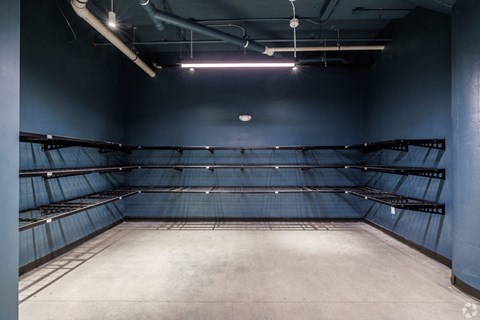 Empty warehouse with grey floor and blue walls.