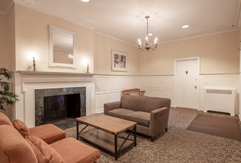 A living room with a fireplace, couch, and chairs.