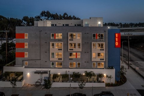 A modern building with a blue and orange sign on the side.
