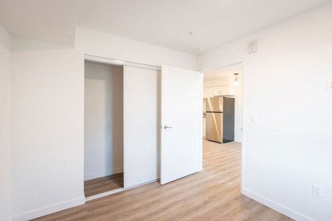 A room with a white door and a brown trash can.