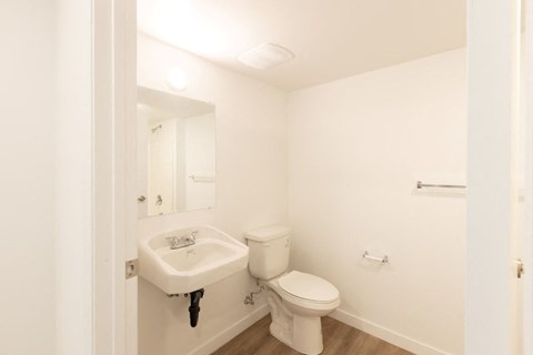 A white toilet and sink in a small bathroom.