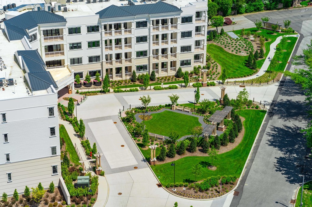 A large white building with a green lawn in front.