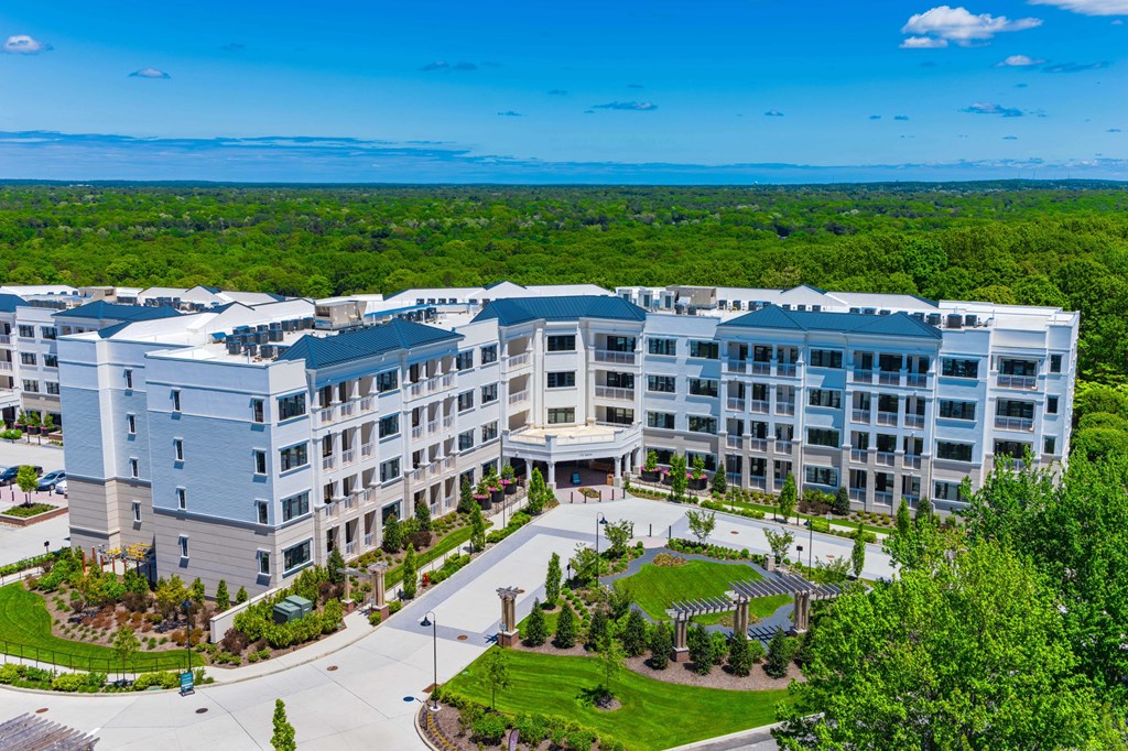 A large white building with a green lawn in front.