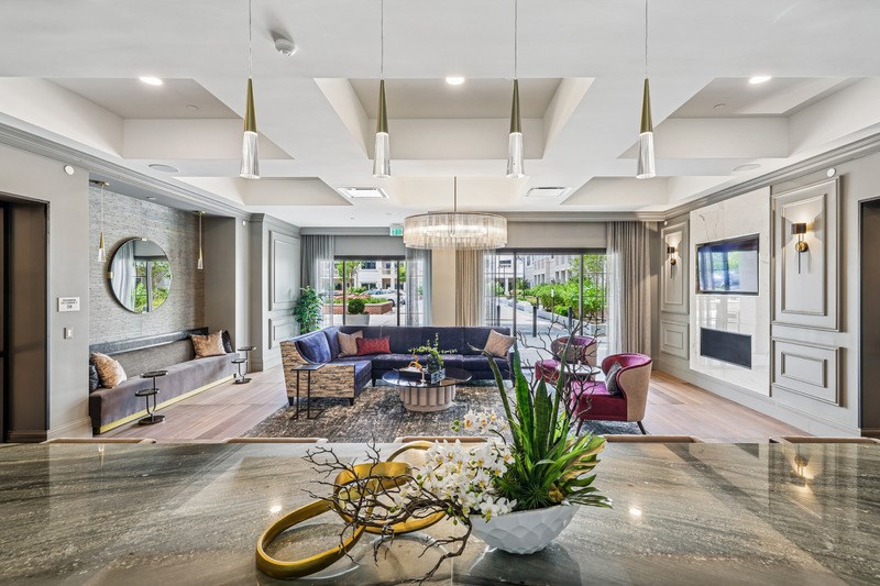 A modern living room with a large sofa set and a chandelier.