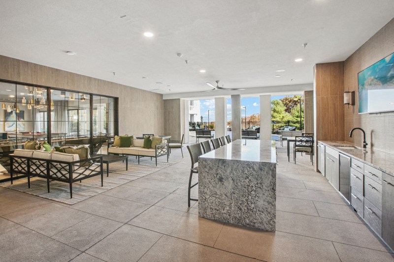 the living room has a large island with a granite countertop and a dining area
