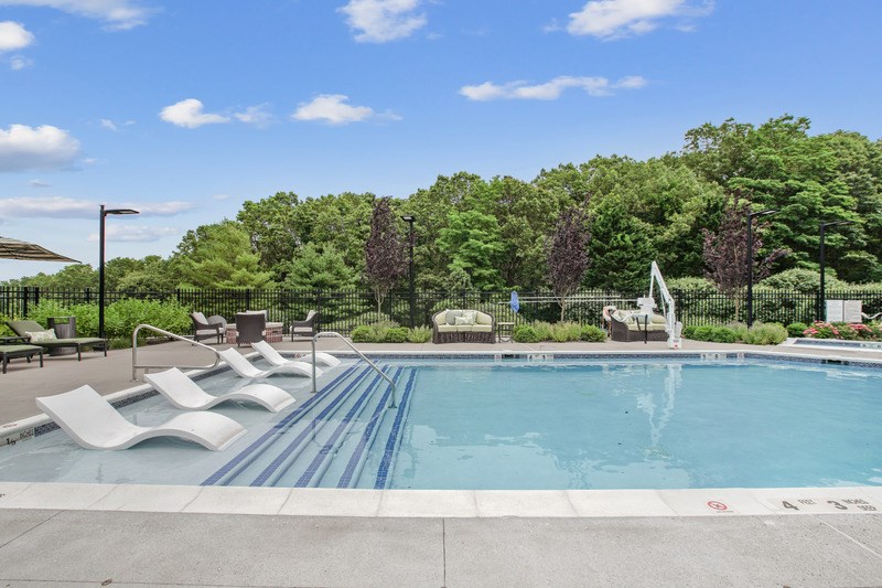 A pool with a waterfall and a fence around it.