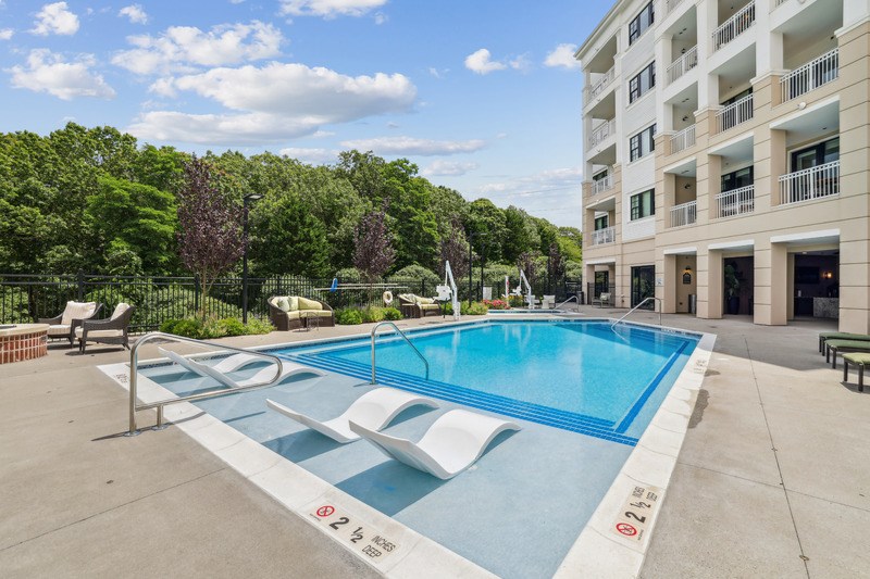 A large swimming pool in front of a multi-story building.