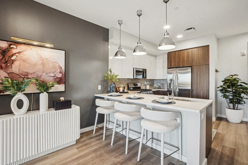 a kitchen with a large island and white stools