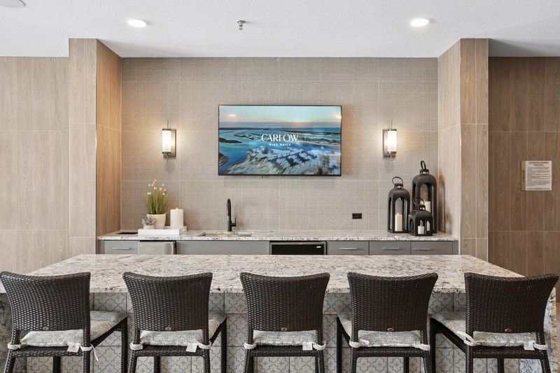 A modern dining area with a large painting of Carrow.