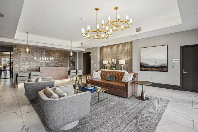 a lobby with couches and chairs and a chandelier