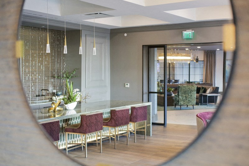 a dining room with a table and chairs in front of a mirror