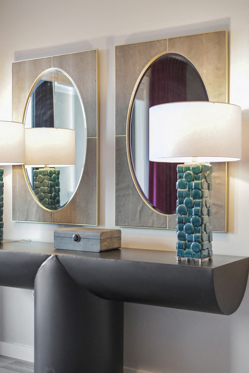 a table with two lamps and three mirrors on it