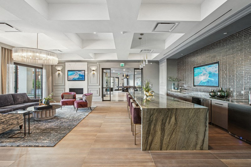 the lobby of a condo with a kitchen and living room