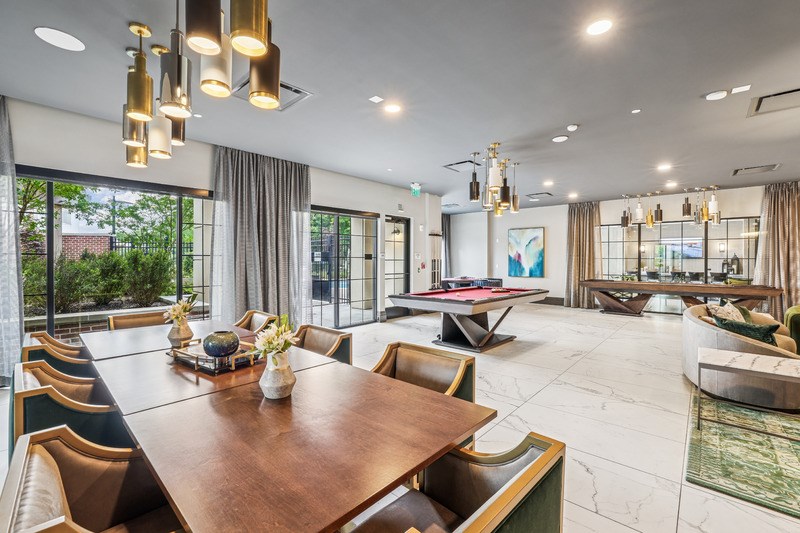 A modern dining room with a large wooden table and chairs.