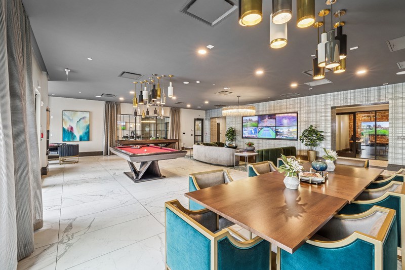 A modern dining room with a pool table and a television.