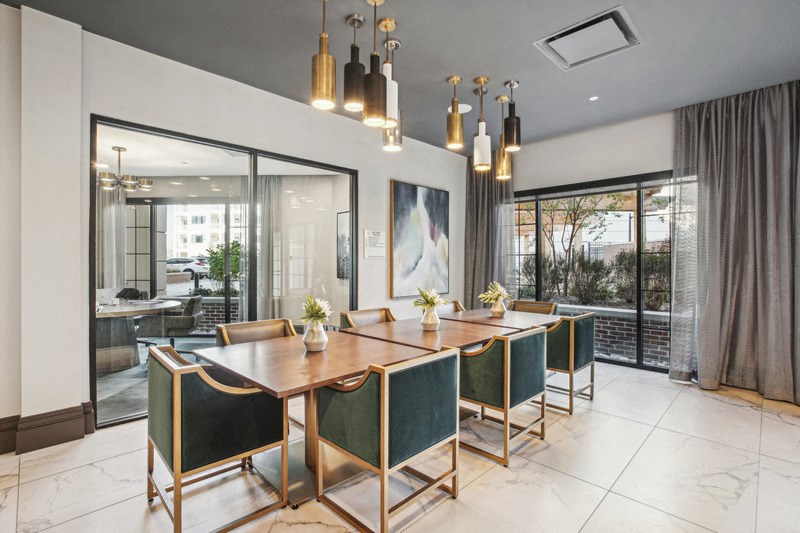 a dining room with a long wooden table and green chairs