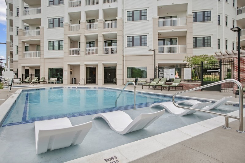 A pool with a slide in front of a building.
