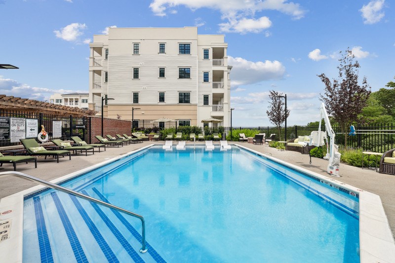 A large swimming pool in front of a white building.
